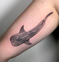 a black and white photo of a shark tattoo on the right arm with dots all over it