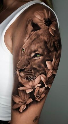 a woman's arm with a lion and flowers tattoo on the left side of her body