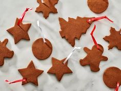 christmas cookies are arranged on a table with red ribbon and decorations hanging from the top