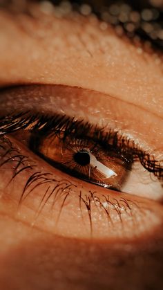 an extreme close - up shot of the eye of a woman's brown eyes