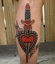 a tattoo on the leg of a person with a knife and heart shaped object in it