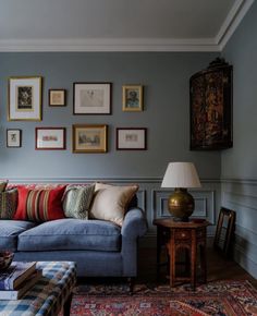 a living room filled with furniture and framed pictures on the wall above it's couch