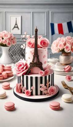 a three tiered cake decorated with pink roses and the eiffel tower