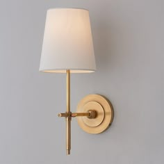 a wall light with a white shade on it's side and a gray background