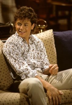 a young man sitting on top of a couch