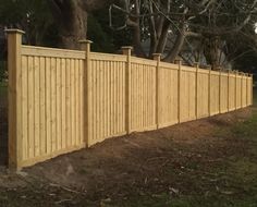 a wooden fence in front of a tree