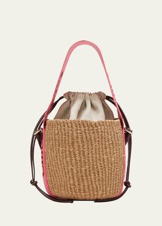 "Find CHLOÉ Woody Small Mifuko Basket Bag In Fair Trade Paper Embellished With Linen on Editorialist. The Chloe x Mifuko \"Woody\" bucket bag is crafted from straw, cotton, and leather. It features a branded flat web top handle, a flat shoulder strap, a drawstring closure, and a leather lining. The bag measures approximately 6.3\"H x 6.7\"W x 6.3\"D and was made in Italy." Pink Travel Bag With Bamboo Handle, Pink Leather Handled Bucket Bag, Flat Web, Web Top, Chloe Logo, Small Basket, Basket Bag, Women Artisans, Mesh Bag