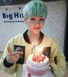 a person holding a cake with candles on it and the caption says, big hit entertainment