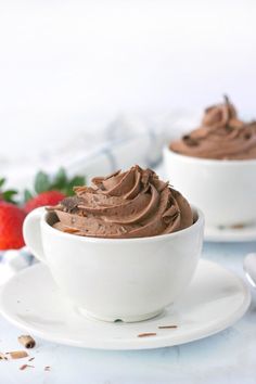 two white bowls filled with chocolate frosting and strawberries