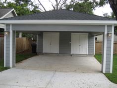 a garage with two doors on the front and one door open to let in light