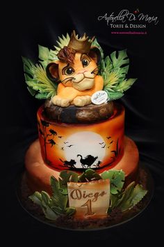 a lion cake is decorated with fondant leaves and an animal figurine on top