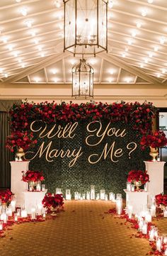 a wedding ceremony with candles and flowers on the aisle, which says will you marry me?