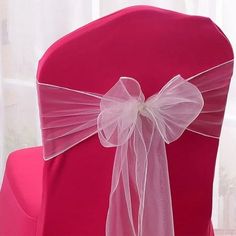 the back of a red chair with a white bow on it's sasher