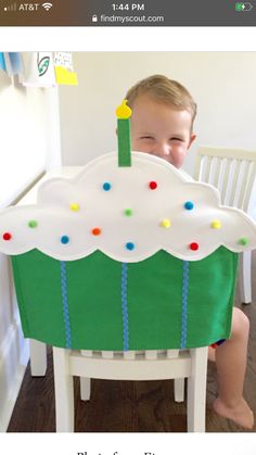 a little boy sitting in front of a cake shaped chair