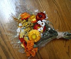 a bouquet of flowers sitting on top of a wooden table next to a piece of string