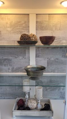 a shelf with candles and bowls on it