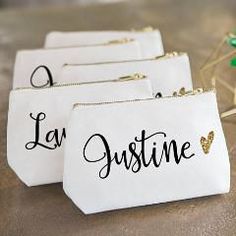 four small white bags with the word la jostine written on them, sitting next to some flowers