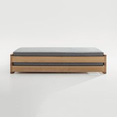 a wooden box sitting on top of a white floor next to a black and brown pillow