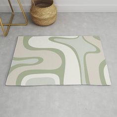 a rug with an abstract design on the floor next to a basket and planter