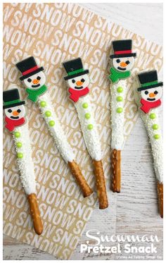 four snowman pretzel snacks on top of a piece of paper