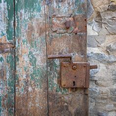 an old wooden door with rusted metal latch