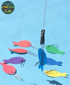 a group of fish hanging from hooks on a blue surface