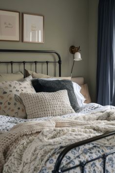 a bed with pillows and blankets on top of it next to a window in a bedroom