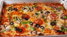 a casserole dish with mushrooms, olives and spinach on it in a metal pan