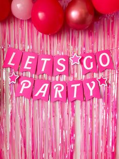 pink party decorations with balloons and streamers in the background that says let's go party