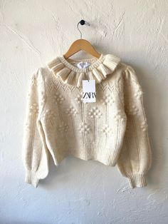 "Zara new with tags fluffy off-white sweater with ruffle at collar, Pom Pom details and ballon sleeves, semi crop length.. Has a 50s, 60s, 70s vibe..  *This is a kid's size 11/12 so fits like an adults petite Xs-ish-small crop length.. Bust 38\" with natural stretch, across shoulders 15\", length 18\" sleeve length 22\" (can dampen, hold and stretch them longer if needed, sweater knits are easy to manipulate shape...)" Beige Ruffled Sweater For Winter, Cute Winter Sweater With Ruffles, Cute Ruffled Winter Sweater, White Puff Sleeve Sweater For Fall, Chic Cream Puff Sleeve Sweater, Cream Puff Sleeve Top For Winter, Pom Pom Sweater, Beige Pullover, Pull Beige