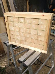 a wooden box sitting on top of a metal step ladder