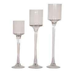 three clear wine goblets are lined up on a white background, one is empty