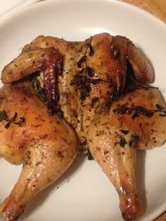 chicken with herbs on it sitting on a white plate