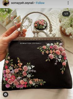 a hand holding a purse with flowers on it