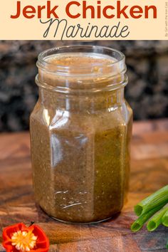 a jar filled with pesto sauce sitting on top of a wooden table next to green beans