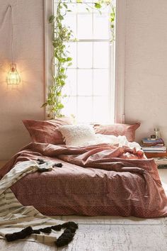 an unmade bed sitting in front of a window