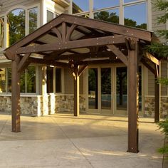 an outdoor covered patio area in front of a house