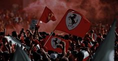 a crowd of people holding red and white flags