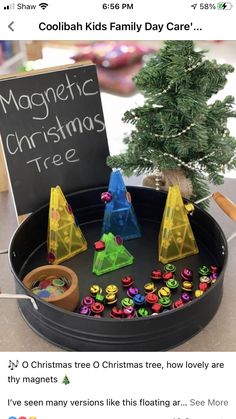 a christmas tree is in a tray with magnets on it and a sign that says magnetic christmas tree