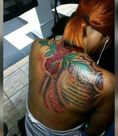 a woman with red hair and tattoos on her back