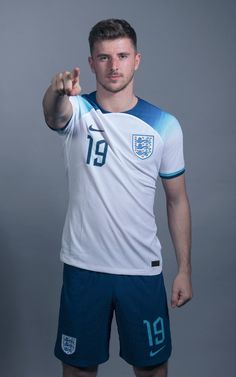 a soccer player poses for a photo in his england kit, which features the number 19