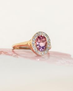 *One of a Kind* hand-carved 14k Yellow Gold ring, set with a stunning oval Pink Tourmaline, surrounded by a halo of White Diamonds. Center Tourmaline is approx. 6 x 8mm and 1.38 ct. Created to inspire deeply devoted unconditional love, reminding you of your innate worthiness and beauty, and to harmonize your strength, softness and power. Natural inclusions may be present within the stone. 💌 Please write desired size (between 4-8) in *Notes* section at checkout. * Pink Tourmaline is amazing for Oval Tourmaline Halo Setting Jewelry, Oval Tourmaline Jewelry With Halo Setting, Oval Tourmaline Ring With Center Stone, Heirloom Oval Sapphire Ring With Halo Design, Oval Sapphire Ring With Halo Setting In Heirloom Style, Heirloom Oval Halo Ring With Bezel Setting, Beacon Of Light, Inner Light, Love Yourself First