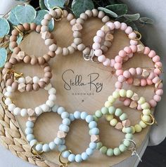 a bunch of bracelets that are sitting on a table next to some plants and flowers