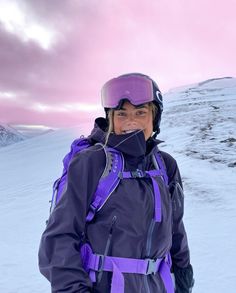 a woman standing on top of a snow covered slope