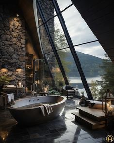 a large bath tub sitting in the middle of a bathroom next to a stone wall