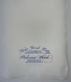 a white handkerchief with blue and red writing on the front is folded in two rows