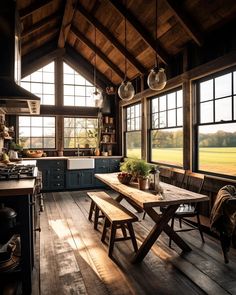 a rustic kitchen with wooden floors and large windows overlooking the field outside at sunset or dawn