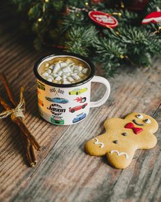 a cup of hot chocolate with marshmallows in it and a gingerbread cookie