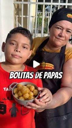 a man holding a bowl of food next to a little boy