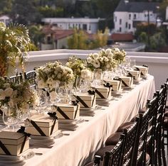 there are many vases with flowers in them on the long table at the wedding reception